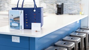 Een keukenblad met een blauw eiland, stoelen en een koffiezetapparaat.