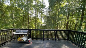 A wooden deck with a barbecue grill and a box of Duraflame charcoal.