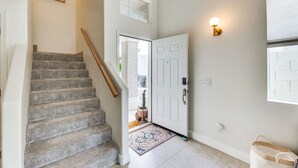 Un escalier menant à une porte sur laquelle est fixée une applique lumineuse.