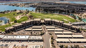 A large building with multiple parking lots and a golf course.