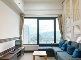 Deluxe Condo, 2 Bedrooms, City View | Living area | 21-inch Smart TV with digital channels