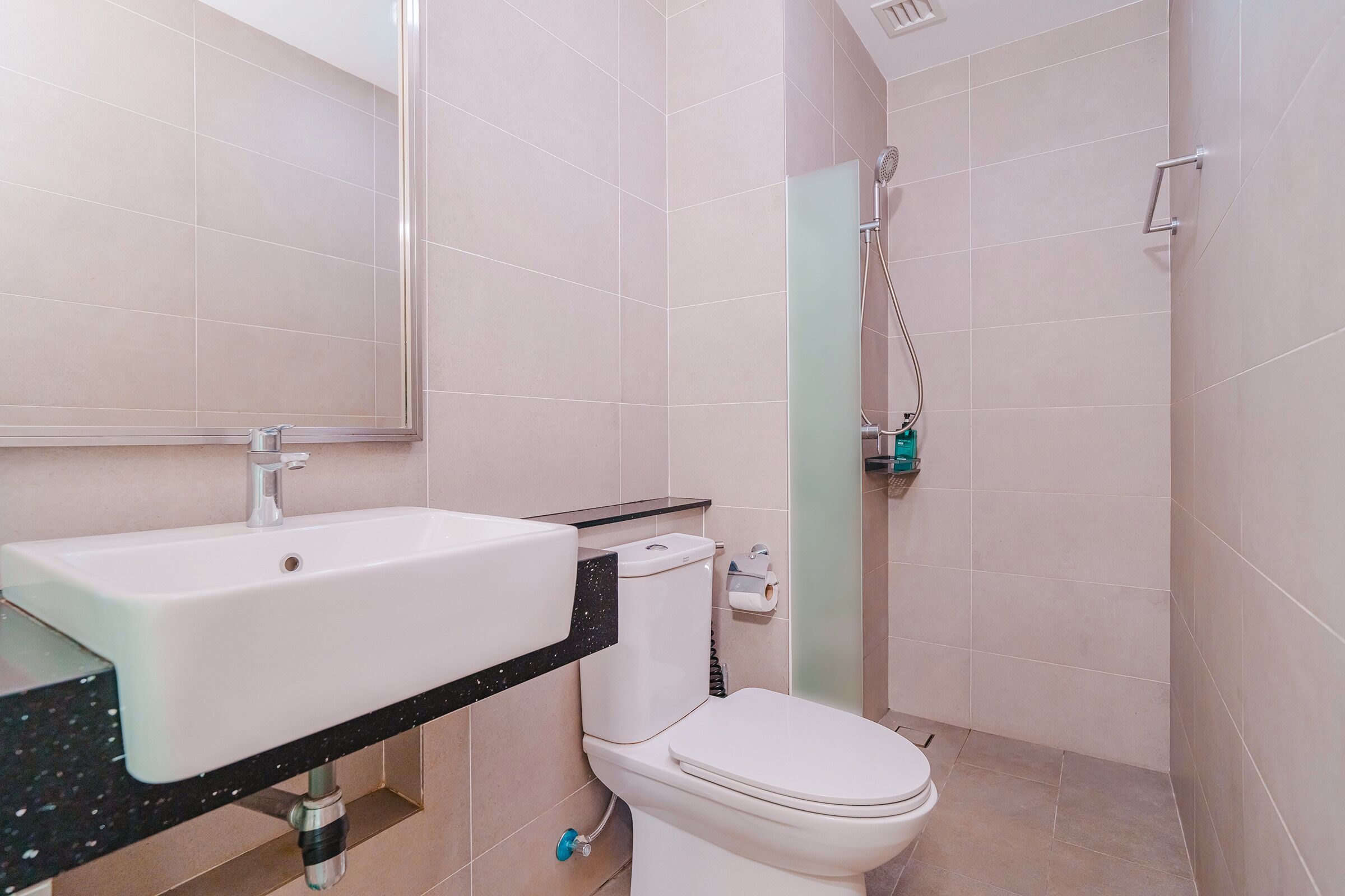 Un baño con lavamanos, inodoro y ducha blancos.