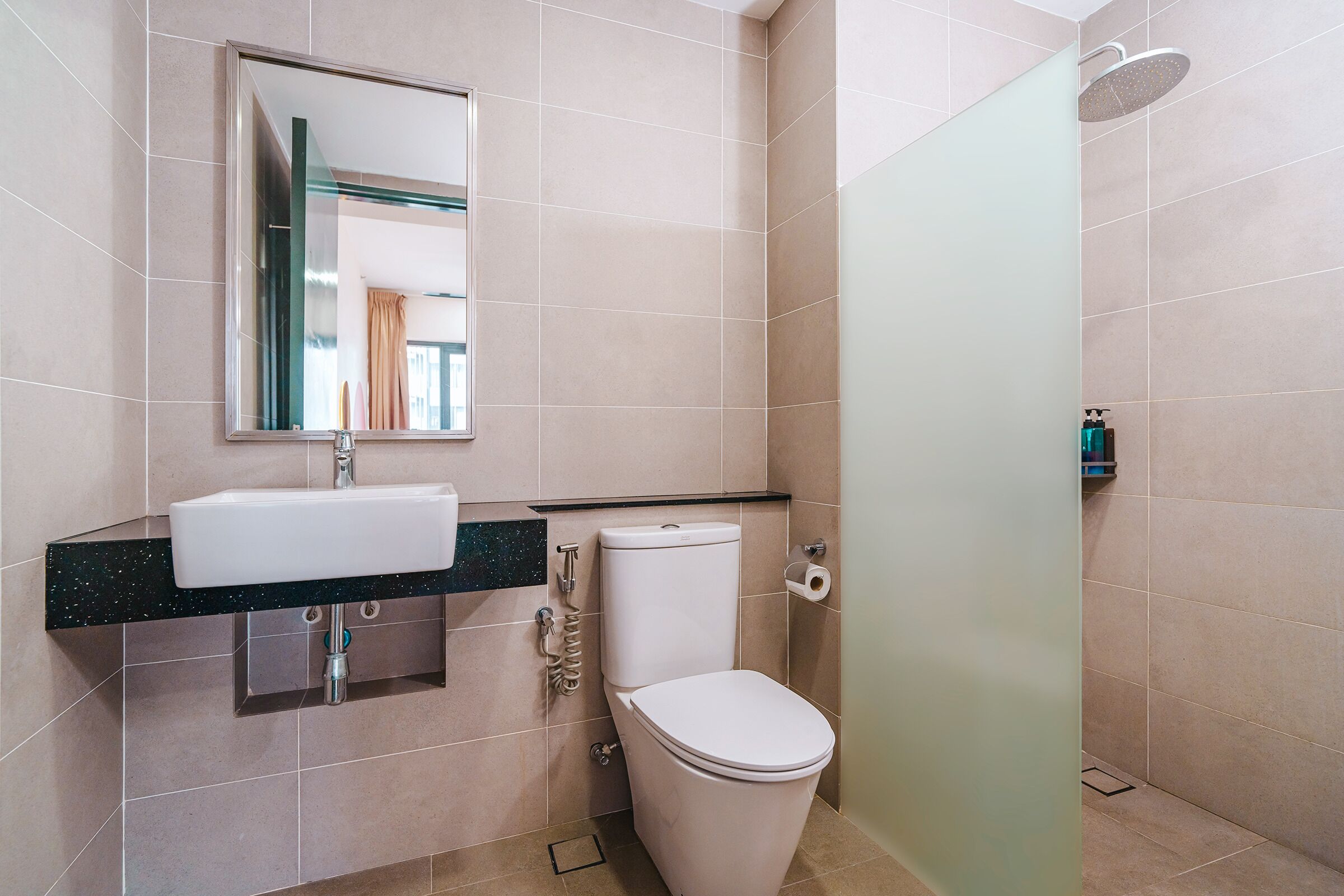Une salle de bain moderne équipée d’un lavabo, de toilettes et d’une douche.