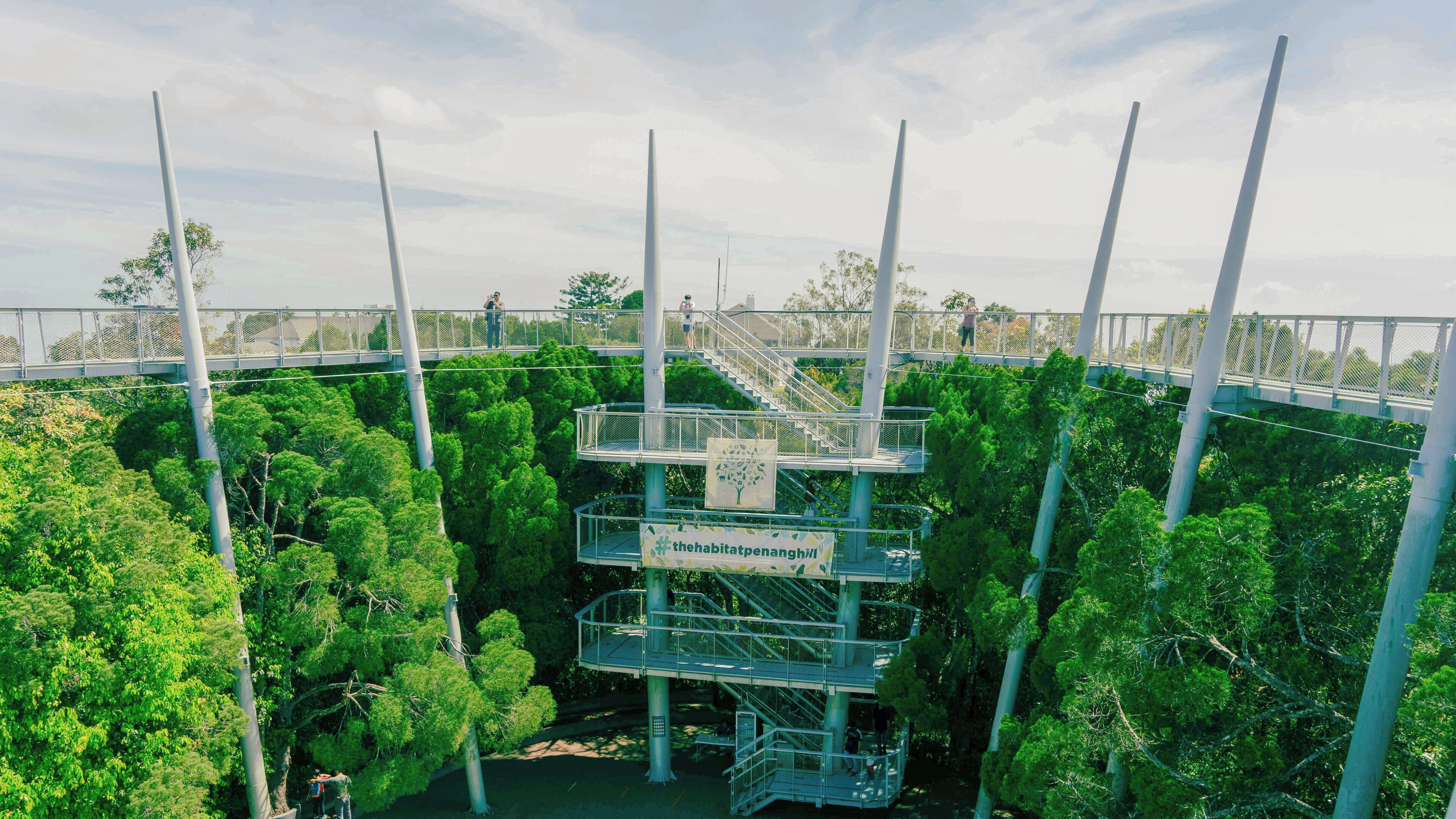 A multi-level observation deck with metal railings and a banner reading "the habitatpenanghill".