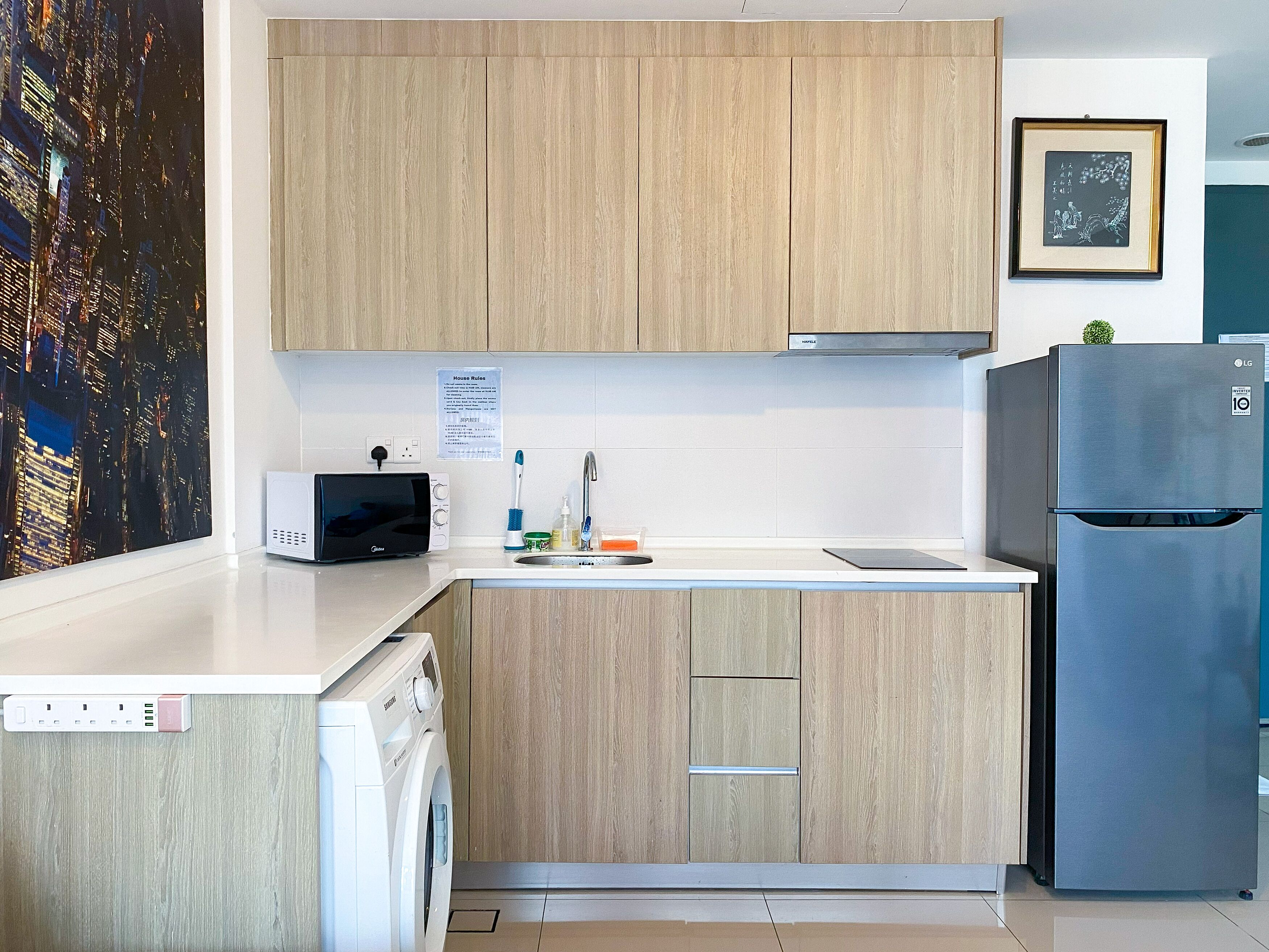 A modern kitchen with wooden cabinets, a built-in washing machine, a refrigerator, and a toaster.