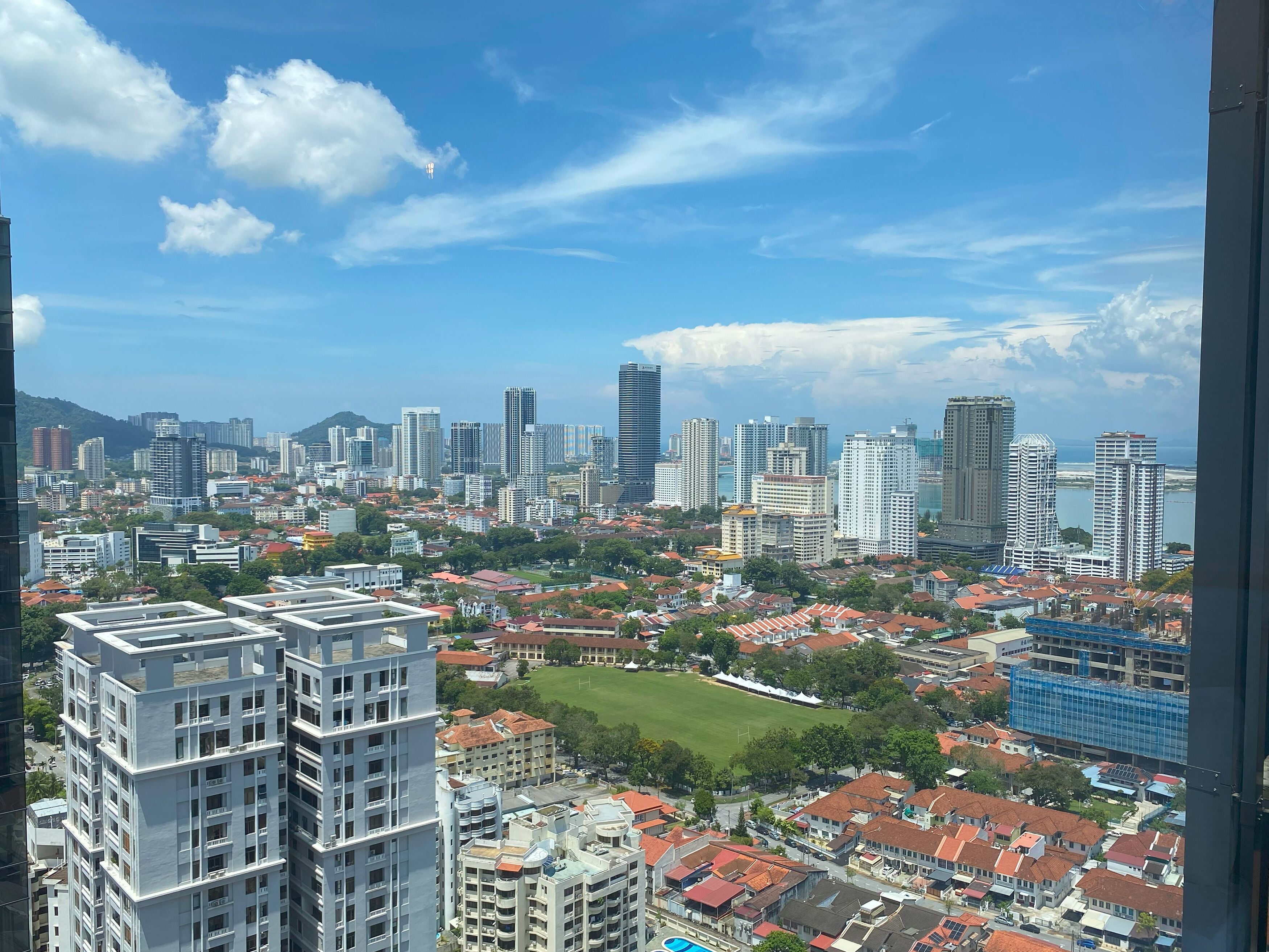 A cityscape with high-rise buildings, a mix of residential and commercial structures, and a clear sky.