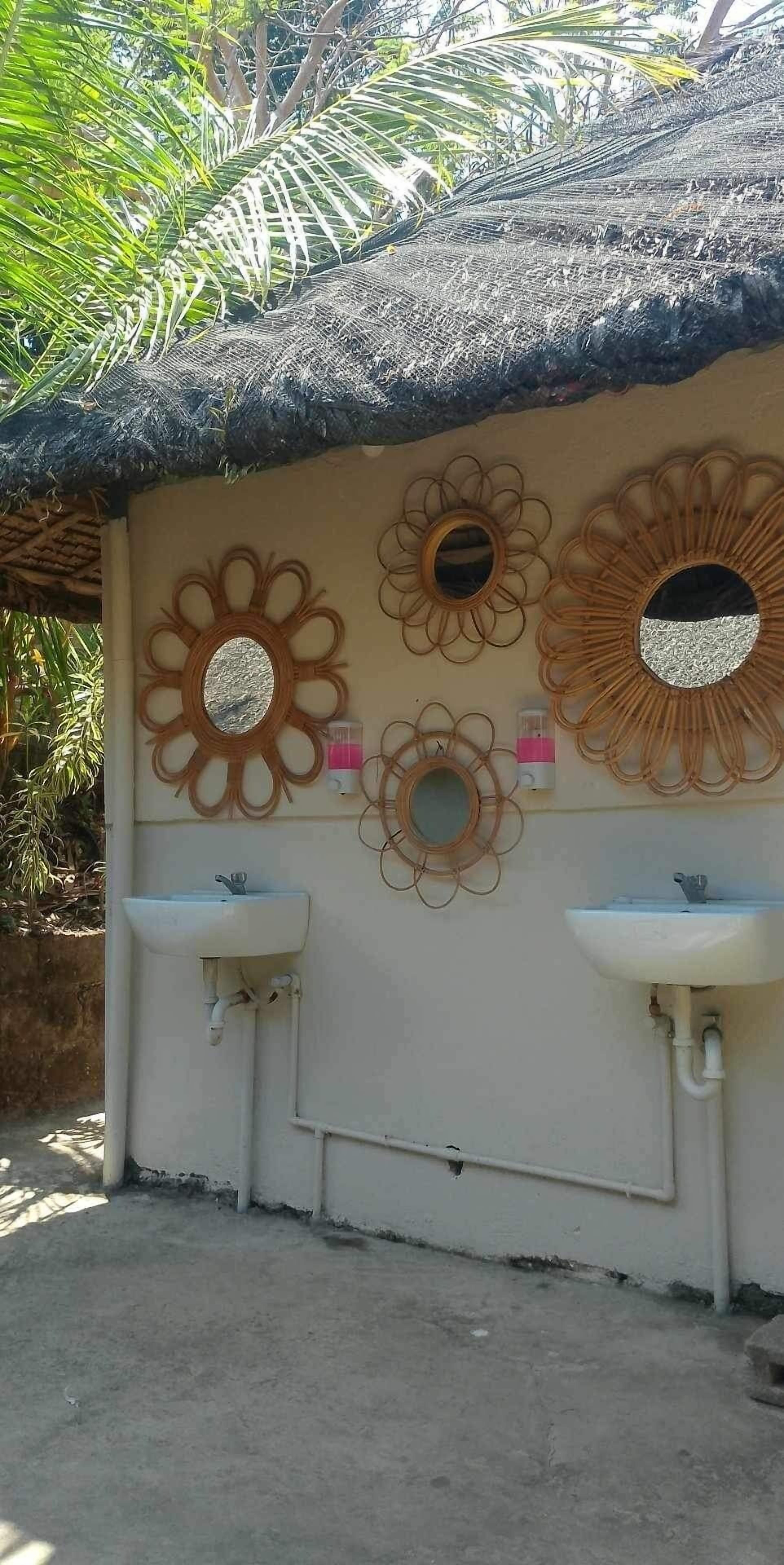 Un baño con tres espejos montados en la pared y dos lavamanos.