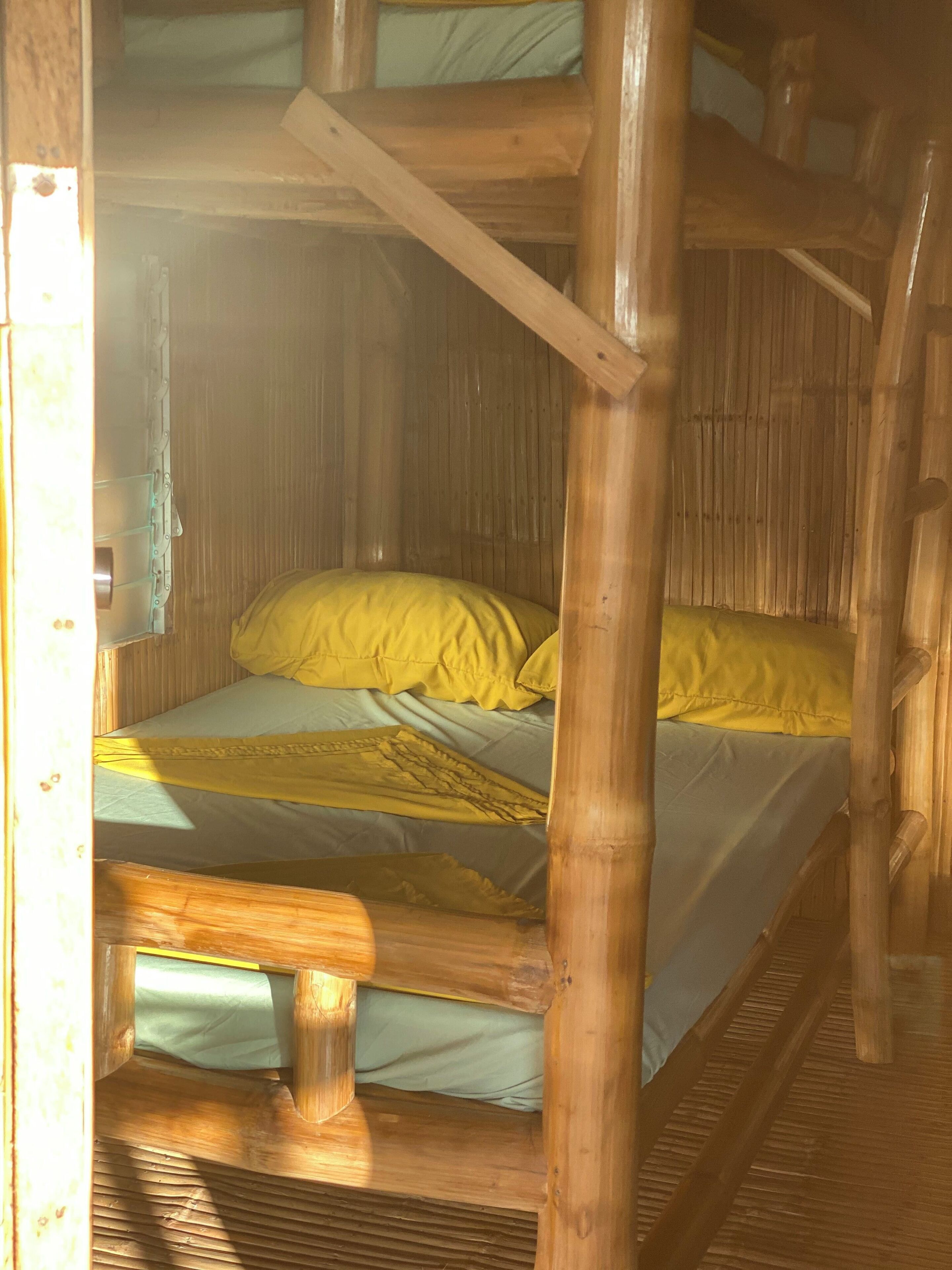 Una cama litera con ropa de cama amarilla en una habitación de cabaña de madera.