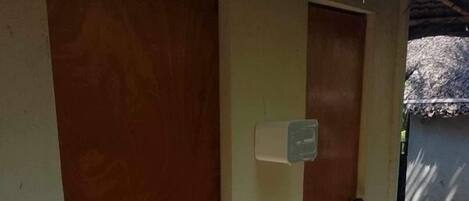 A hallway with two wooden doors, one of which has a small, white, rectangular object attached to it.