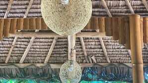 A thatched roof structure with hanging spherical light fixtures. - Rustique Rue (Mabini)