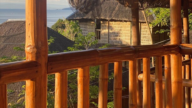 A bamboo-framed structure with a thatched roof, overlooking a coastal landscape. - Rustique Rue (Mabini)