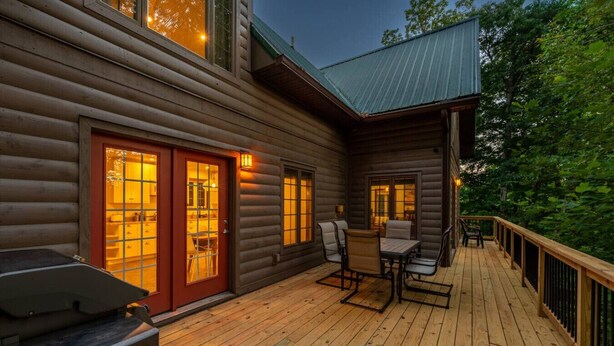 A log cabin with a deck, a dining area, and a red door. - Fels Haus- Hot Tub, WiFi, Gas Grill, located on Cliffview Resort (Campton)