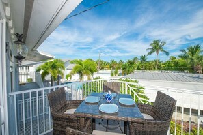 Enjoy al fresco dining with a view of the lush landscape from this balcony's wicker table and chairs.