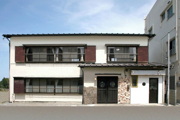 A two-story building with a flat roof, large windows, and a small balcony. - MOANA (Shimoda)