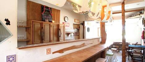 Una cocina rústica con armarios de madera, una barra y una zona de estar con taburetes.