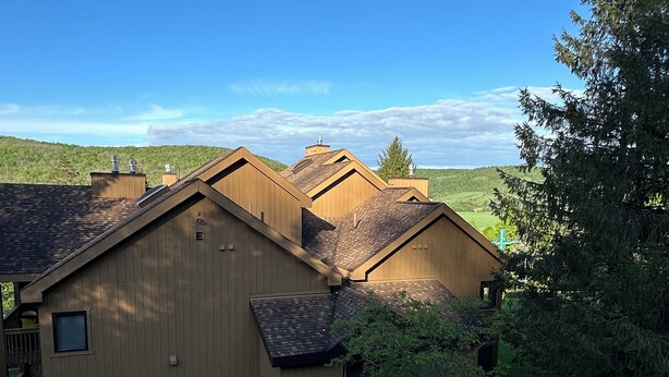 Ein Holzhaus mit einer Terrasse und Blick auf die umliegende Landschaft.