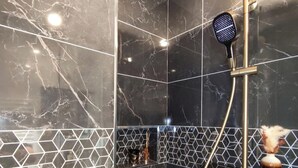 Een moderne badkamer met marmeren wanden en een geometrisch tegelpatroon.