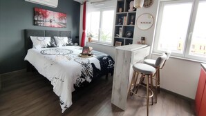 Een moderne slaapkamer met een bed, bureau en raam.