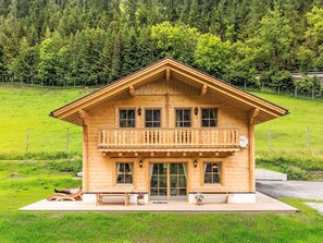 Eine Holzhütte mit Balkon, großen Fenstern und einem Schild, das sie als Pension kennzeichnet.