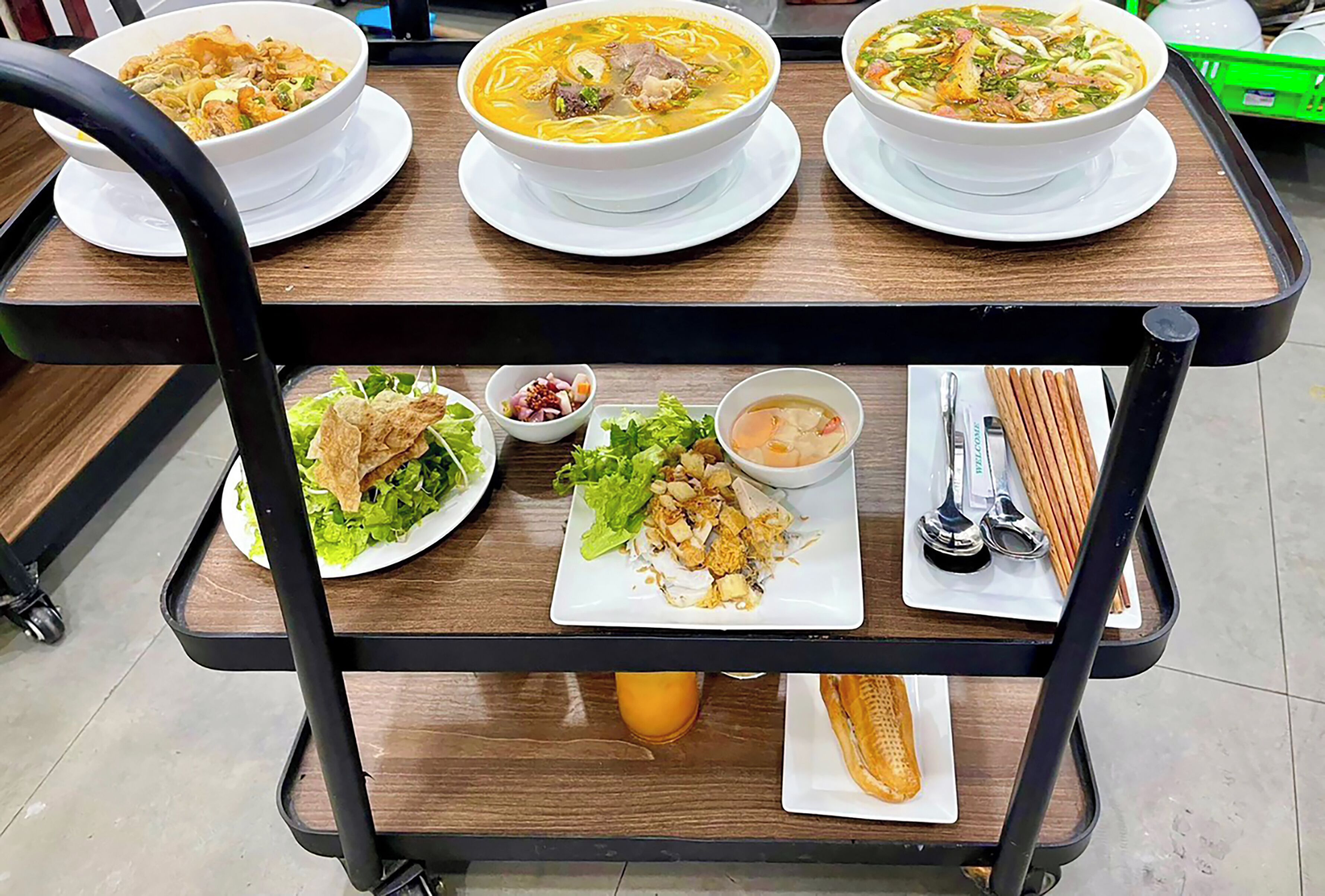 Een eetkraam met drie soepkommen, een saladebord, een soepkom en een bord met broodstengels.