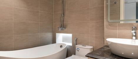 A modern bathroom with a freestanding bathtub, a toilet, and a vanity with a sink.