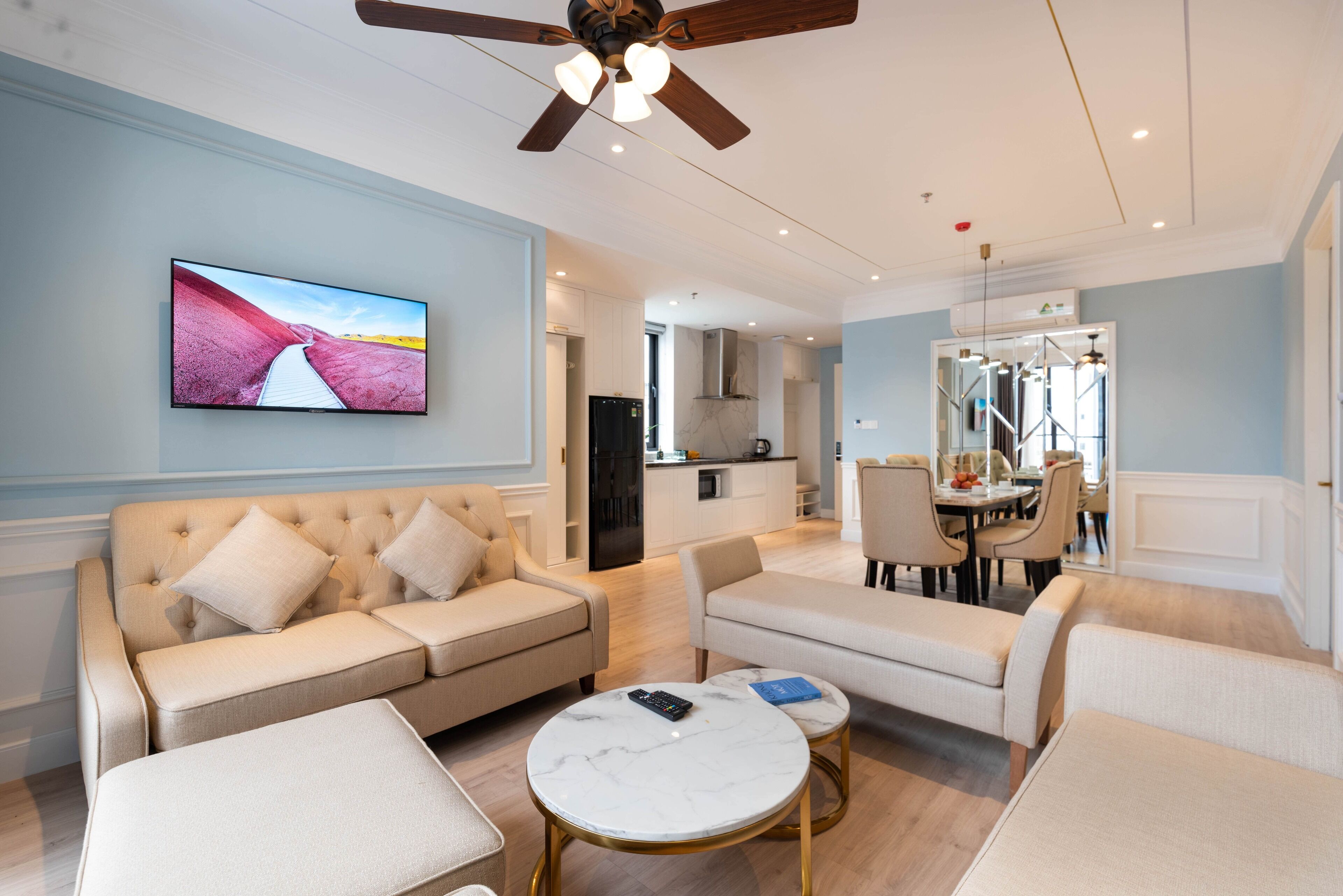 A modern living room with a sofa, a coffee table, and a TV mounted on the wall.