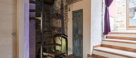 Un escalier avec des marches en bois, un mur en pierre et une porte bleue.