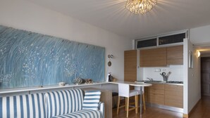 Een moderne keuken met houten kastjes, een wit aanrecht en een gestreepte bank.