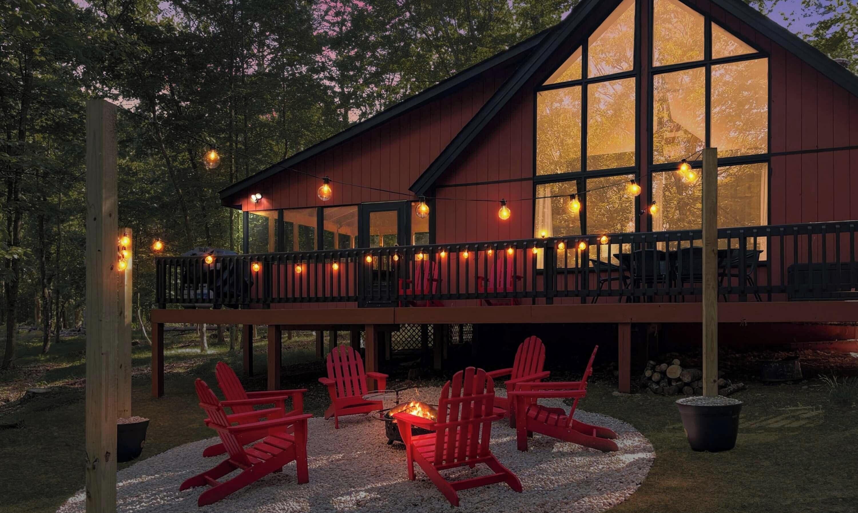 Une cabane dotée d’une terrasse, d’un espace salon extérieur et d’un foyer.