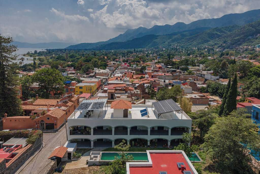 A town with a prominent building featuring a central courtyard and a swimming pool.