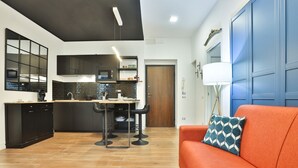 Una cocina moderna con comedor, un sofá y una puerta azul.