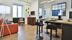 Una cocina moderna con una isla central, taburetes de bar y una mesa de comedor.