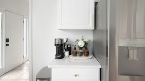 A kitchen with a coffee maker, water dispensers, and a refrigerator. - Family & Pet Friendly Modern Townhouse (Alabaster)