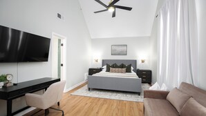 A bedroom with a bed, a desk, a chair, a TV, and a ceiling fan. - Family & Pet Friendly Modern Townhouse (Alabaster)