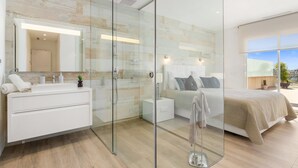 Een moderne badkamer met een douchecabine van glas, een wit wastafelmeubel en een grote spiegel.