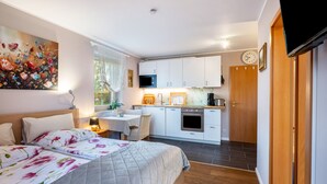 Ein Schlafzimmer mit einem Bett, einem Schreibtisch und einer Küchenzeile.