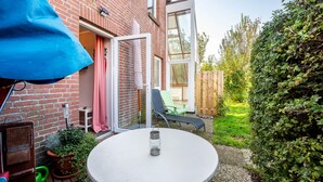 Eine Terrasse mit Tisch, Stühlen und einem Blumentopf.
