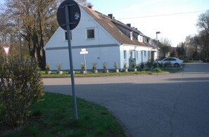 A residential building with a white facade, a visible garage door, and a street sign.