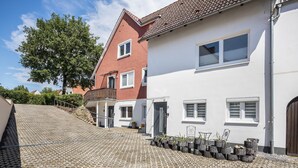 Une rue résidentielle bordée de maisons, avec une allée pavée et un arbre.