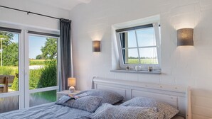 Une chambre à coucher avec un lit, une fenêtre et une table de chevet.
