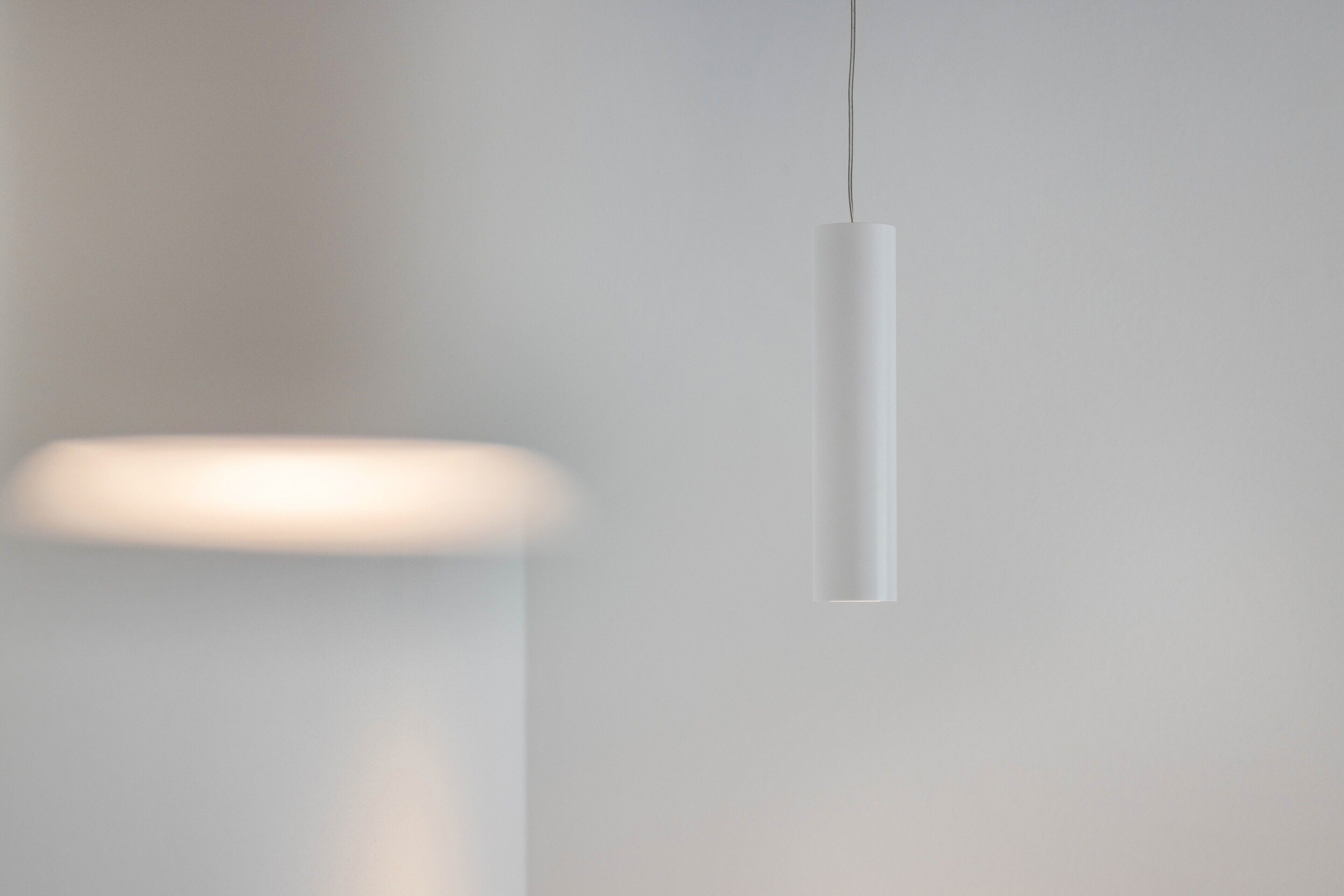 A minimalist pendant light fixture in a modern interior setting.
