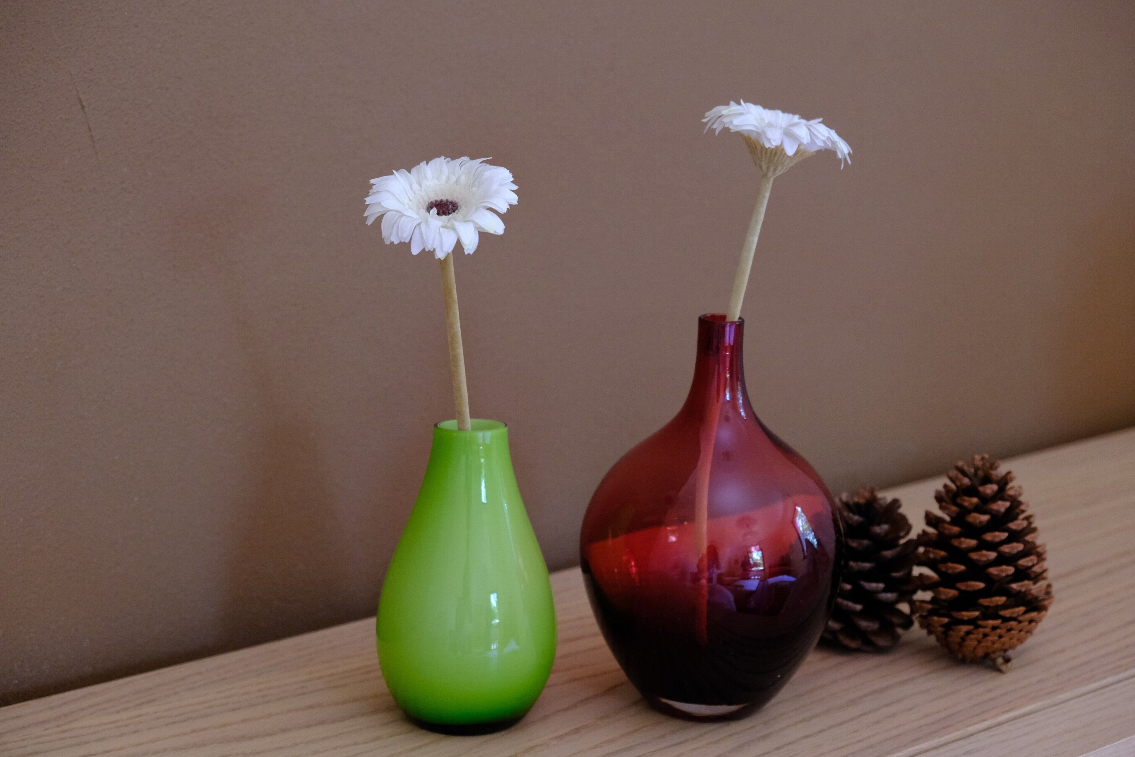 Dos jarrones con flores sobre una superficie de madera.