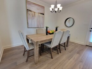 Ein Essbereich mit einem Holztisch und vier gepolsterten Stühlen.