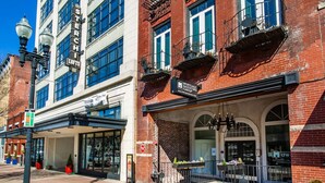 A building with a sign for 'STERCHI LOFTS' and 'MORTGAGE INVESTORS GROUP'. - Downtown Loft w/Parking, Fitness & Movie room (Knoxvile)