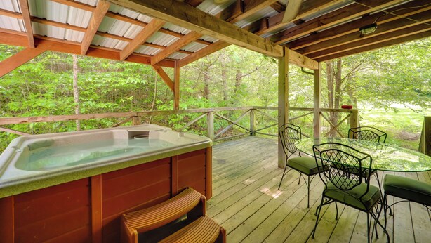 A wooden deck with a hot tub, chairs, and a table. - Hot Tub Haven! Blue Ridge Mountain Gem on 92 Acres (Marion)
