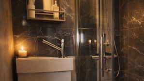 A modern bathroom with a glass-enclosed shower, a white sink, and a lit candle. - Cambridge Garden Studio                  Private Entrance & Free Parking (Cambridge)
