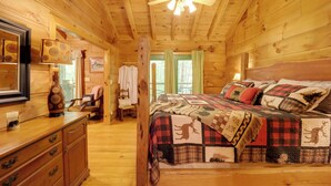 Ein Holzblock-Interieur mit einem Bett, einem Schminktisch und einem Deckenventilator.