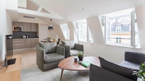 A modern loft apartment with a kitchen, living area, and large windows.