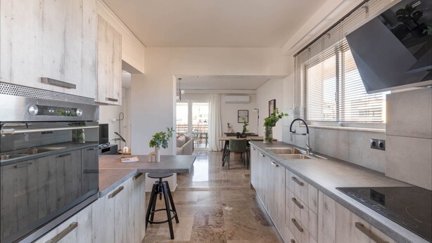 Een moderne keuken met roestvrijstalen apparatuur, een centraal eiland en een eetgedeelte met uitzicht.
