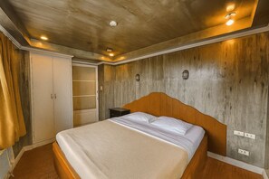Una camera da letto con testiera in legno, un letto con lenzuola bianche, un comodino e un armadio con specchio.